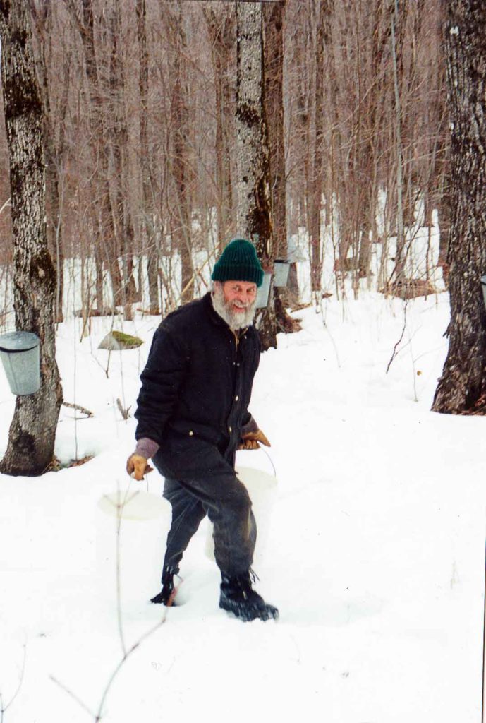Gene Sage carrying buckets of sap