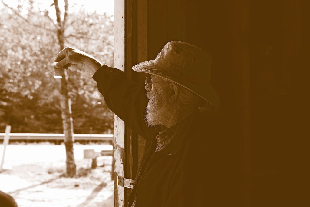 Our Sugarmaster examining the syrup for purity in sunlight